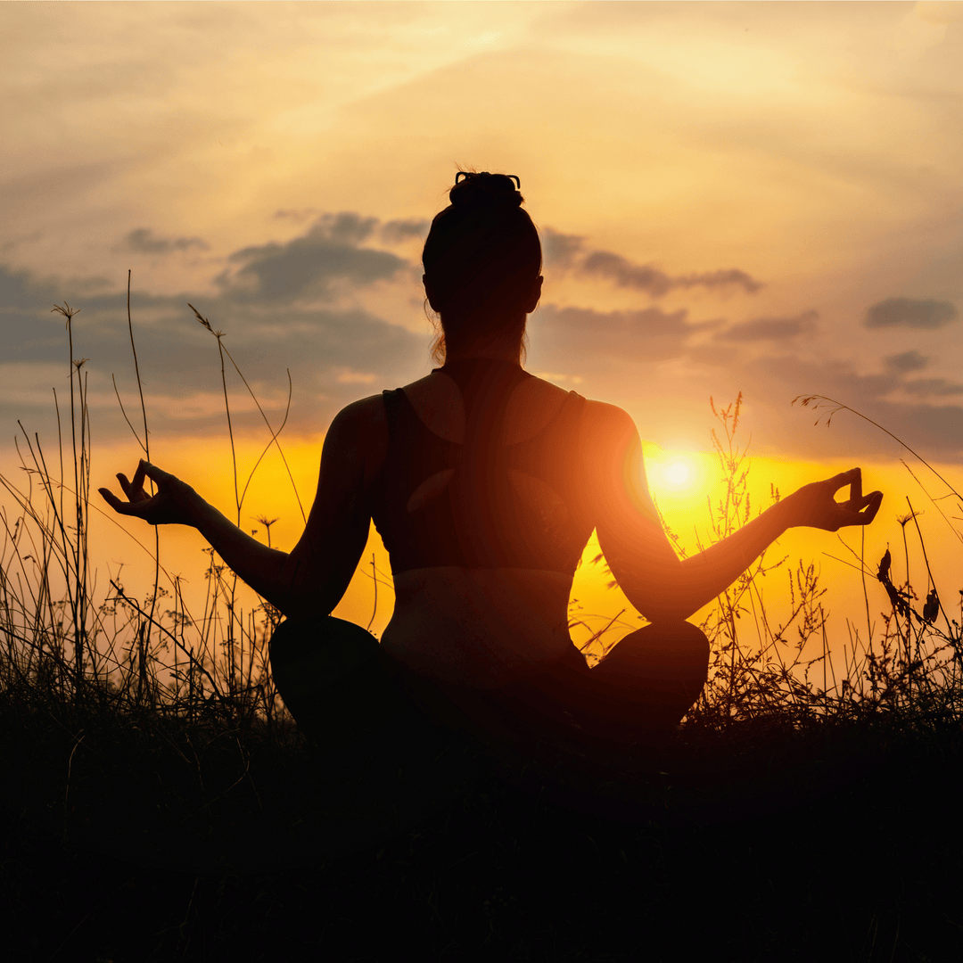 jeune femme qui médite au coucher de soleil pour mieux dormir et s'endormir